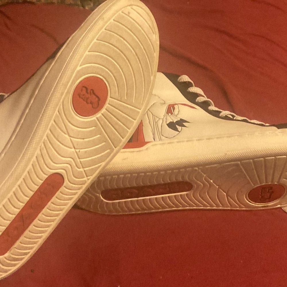 White, black, and red coach shoe with Disney character, Cruella De Vil.